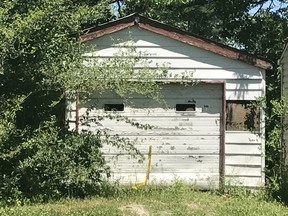 Trees grow in front of the entrance of a garage Tuesday, June 6, 2017, where the remains of a 7-year-old child was found in Centreville, Ill. Centreville police Sgt. DeMarius Thomas Sr. told the St. Louis Post-Disaptch that police believe the child was killed in nearby Belleville, Ill, and dumped in the garage. (Christine Byers/St. Louis Post-Dispatch via AP)