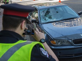 A pedestrian was struck by a westbound car on Jasper Avenue at 105 Street just before the lunch hour in Edmonton on June 7, 2017. The man may have been involved in a scuffle on the sidewalk before running into traffic. Photo by Shaughn Butts / Postmedia