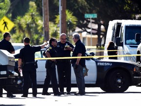 Fresno police officers confer in front of the scene of a shooting Wednesday, June 7, 2017. (John Walker/Fresno Bee via AP)