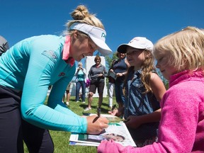 Brooke Henderson of Smiths Falls signs autographs for young fans during the Pro-Am event at the LPGA Classic at Whistle Bear Golf Club in Cambridge on Wednesday. (Frank Gunn/The Canadian Press(