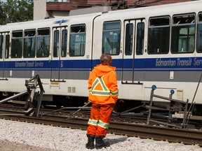 An EPCOR employee looks over broken components after a northbound Edmonton Transit System LRT train broke down between 92 Street and 95 Street in Edmonton on June 7, 2017 after a disconnection from an overhead power line. Ian Kucerak / Postmedia