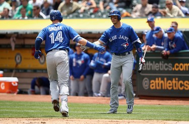 Justin Smoak #14 of the Toronto Blue Jays is congratulated by Troy Tulowitzki #2 after he hit a home run against the Oakland Athletics in the second inning at Oakland Alameda Coliseum on June 7, 2017 in Oakland, California.  (Photo by Ezra Shaw/Getty Images)