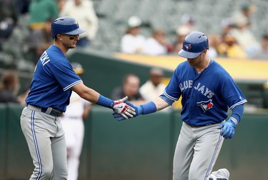Justin Smoak #14 of the Toronto Blue Jays is congratulated by Troy Tulowitzki #2 after he hit a home run in the 10th inning against the Oakland Athletics at Oakland Alameda Coliseum on June 7, 2017 in Oakland, California.  (Photo by Ezra Shaw/Getty Images)