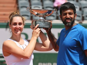 Canada's Gabriela Dabrowski and India's Rohan Bopanna hold the trophy as they celebrate winning their mixed doubles final match against Anna-Lena Groenefeld of Germany and Robert Farah of Colombia in two sets 2-6, 6-2 (12-10), of the French Open tennis tournament at the Roland Garros stadium, in Paris, France, Thursday, June 8, 2017. (AP Photo/David Vincent)