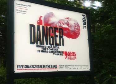In this June 7, 2017 photo, "Danger knows full well that Caesar is more dangerous than he," reads a sign promoting The Public Theater's production of Julius Caesar in New York's Central Park. Gregg Henry, the actor who starred in Shakespeare's "Julius Caesar" on a New York stage wears a Donald Trump-like costume to play the powerful Roman politician betrayed by his top aide and knifed to death. (AP Photo/Verena Dobnik)