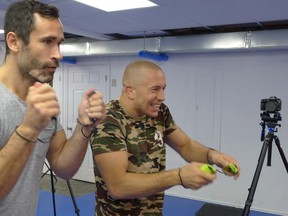 Former UFC champion Georges St. Pierre, right, plays trainer Jorge Blanco on Nintendo Switch in Toronto on June 8, 2017. (THE CANADIAN PRESS/Neil Davidson)