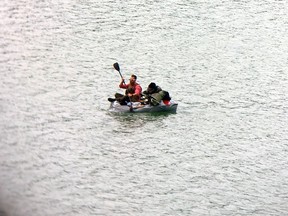 A man and his dog are seen in a duct-taped boat in Juneau, Alaska. (U.S. Coast Guard photo)