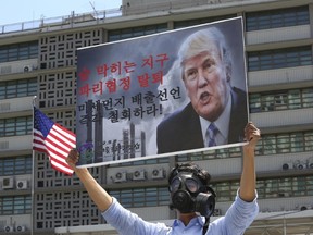 A South Korean environmental activist participates in a protest to denounce the U.S. withdrawal from the Paris climate accord, in front of the U.S. Embassy in Seoul, South Korea, earlier this week. Columnist Gwynne Dyer says that, like past cases, the international signatories to the agreement are obliged to act, with or without the U.S. (Ahn Young-joon/The Associated Press)