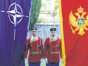 Montenegrin honour guards stand next to NATO and Montenegrin flags during a ceremony in the capital Podgorica Wednesday. Montenegro became NATO?s 29th member on Monday just as the crucial Atlantic alliance appeared imperilled by the U.S. president?s ambiguous commitment to its mutual defence. (SAVO PRELEVIC/Agence France Presse)