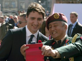 Canadian Prime Minister Justin Trudeau has his photo taken with military personnel following the Poppy of Peace Ceremony in Arras, France, Sunday, April 9, 2017. (THE CANADIAN PRESS/Adrian Wyld)
