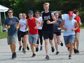 Students from Medway secondary school jog around their cinder track Friday during a fundraiser to help raise money for a new track-and-field facility at the school. The facility will be built in memory of late student athlete Roy Davis. (MORRIS LAMONT, The London Free Press)