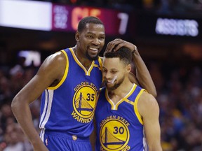 Golden State Warriors' Kevin Durant hugs Stephen Curry during the first half against the Cleveland Cavaliers in Game 4 of the NBA Finals on June 9, 2017. (AP Photo/Tony Dejak)