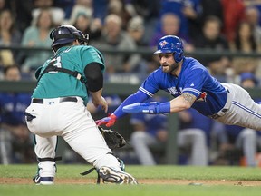 Toronto Blue Jays' Kevin Pillar dives for home plate as Seattle Mariners catcher Mike Zunino makes a tag during the seventh inning of a out game at Safeco Field on June 9, 2017 in Seattle, Wash. (Stephen Brashear/Getty Images)