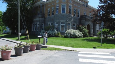 In this photo taken on June 8, 2017 in Derby Line, Vt., a border post and planters show the U.S.-Canadian border where it leads to the Haskell Opera House and library, a building located in the two countries. Brian and Joan Dumoulin, from the nearby neighbourhood of Beebe Plain, say they're having a hard time selling their home that straddles the border. (AP Photo/Wilson Ring)