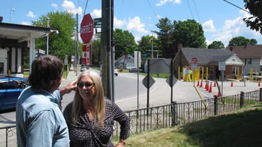 In this photo taken on June 8, 2017 in Derby, Vt., Brian and Joan Dumoulin stand in front of their apartment building that straddles the U.S.-Canadian border. To the left is a Canadian border post, and to the right, a U.S. post. Straddling the border between the Derby neighbourhood of Beebe Plain, Vt., and Stanstead, Que., has made it more difficult to sell. (AP Photo/Wilson Ring)