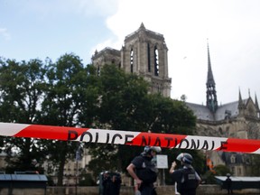 In this Tuesday, June 6, 2017 file photo, police officers seal off the access to Notre Dame cathedral in Paris, France. The chief prosecutor in Paris said Saturday, June 10 2017, that a hammer-wielding man who attacked police officers patrolling in front of Notre Dame Cathedral appears to have radicalized himself through the internet and was unknown to French police and intelligence services. (AP Photo/Matthieu Alexandre, File)