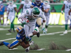 Blue Bombers defensive back Terrence Frederick (35) tackles Roughriders wide receiver Mitchell Picton during the first half in Regina last night. (The Canadian Press)