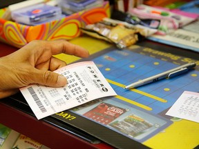 A customer buys a Powerball ticket in a file photo. (AP Photo/G-Jun Yam)