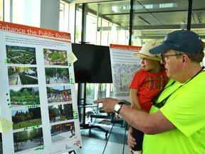 At a Cooper Site public consultation meeting, Craig Thompson and his daughter Jaden check out a few of the ideas proposed for the Grand Trunk Community Hub included in Urban Strategies Inc.’s concept design.