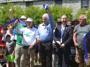From left, K&P Trail advocate Douglas Knapp (with cane), King's Town District Councillor Rob Hutchison and Mayor Bryan Paterson cut a ribbon at the grand opening of the K&P Trail at Douglas Fluhrer Park on Saturday. (Joseph Cattana/For The Whig-Standard)