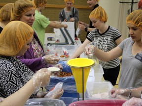 Parishioners from The Church of Jesus Christ of Latter-day Saints in Glenburnie prepare 288 packaged meals of jambalaya at the church on Saturday. The food will be distributed to local organizations. (Steph Crosier/The Whig-Standard)