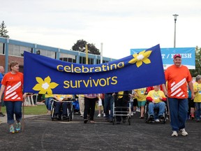 Community champion Linda Torkelson and East Zorra-Tavistock Mayor Don McKay carry a flag celebrating survivors during the survivors' lap at the 18th annual Woodstock Relay for Life on Friday.