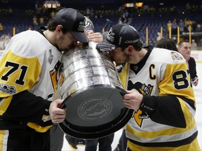Penguins' Evgeni Malkin (71), and Sidney Crosby (87) kiss the Stanley Cup after defeating the Predators in Game 6 of the Stanley Cup final in Nashville on Sunday, June 11, 2017. (AP Photo/Mark Humphrey)