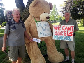Ontario Health Coalition volunteers Don Arkell, left, and Peter Boyle, brought a seven-foot bear to Wallaceburg's Civic Square Park on Saturday morning, to bring awareness of how privatization of health-care is harming Canada's public medicare system.