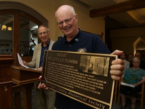 Jason Miller/The Intelligencer 
Rick Hughes (first from left), president, Hastings County Historical society and Bill Kennedy, showcase one of the plaques to be installed commemorating local history such as past floods, historical buildings and the railway.