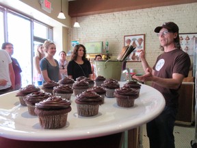 This April 28, 2017 photo shows Jon Payson, owner of The Chocolate Room in Brooklyn, N.Y., explaining how he and his wife started the business in a chat with a group on A Slice of Brooklyn's chocolate tour. The Chocolate Room is one of a number of stops on the tour. In addition to chocolate samples to taste, the tour offers a peek at the chocolate-making process and neighborhood visits. (AP Photo/Beth J. Harpaz)