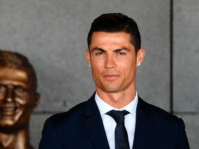 This file photo taken on March 29, 2017 shows Portuguese footballer Cristiano Ronaldo standing beside a bust presented during a ceremony where Madeira's airport in Funchal is to be renamed after Cristiano Ronaldo, on Madeira island. State prosecutors have filed a complaint on June 13, 2017 against the Portuguese star, who they accuse of taking advantage of a corporate structure to defraud the Spanish Treasury of 14.7 million euros. (Francisco Leong/AFP/Getty Images)