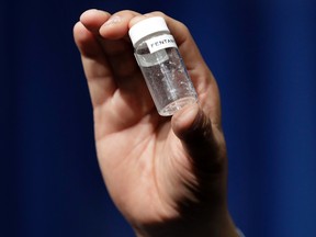 A reporter holds up an example of the amount of fentanyl that can be deadly after a news conference about deaths from fentanyl exposure, at DEA Headquarters in Arlington Va. (AP Photo/Jacquelyn Martin)