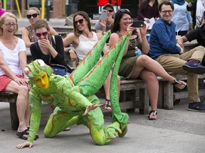 Anne Thomas, left, Alexandra Berney and scores of others were entertained by Cirque du Soleil performers during a lunchtime promotional appearance at the Covent Garden Market in London Tuesday. Cirque du Soleil?s new show OVO is playing at Budweiser Gardens Wednesday through Sunday. Performing as a cricket is Shawn Gregory. (DEREK RUTTAN, The London Free Press)