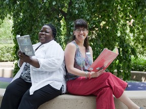 Librarians Ticha Gwaradzimba, left, and Kara McKeown from the London Public Library encourage Londoners to pick up a good book this summer. (Derek Ruttan/The London Free Press)