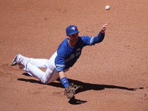 Jays first baseman Justin Smoak flips the ball to a teammate. (GETTY IMAGES)