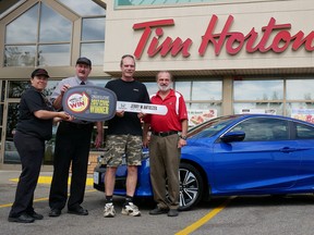 Simcoe's Jerry Antoszek won a Honda Civic during this year's Tim Hortons Roll Up the Rim to Win promotion. The official presentation was made Wednesday morning in Tillsonburg where Antoszek bought the winning large regular double-double. From left are Sheila Klassen, manager of the Simcoe Street Tim Hortons; Randy Salverda, owner of the Tillsonburg Tim Hortons franchises; Antoszek; and Darryl Lazowski, owner of Simcoe Honda.Chris Abbott/Tillsonburg News