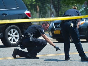 Crime scene investigators search for evidence at the scene of a shooting in Alexandria, Va., Wednesday, June 14, 2017, where House Majority Whip Steve Scalise of Louisiana, and others, were shot during a congressional baseball practice. (AP Photo/Cliff Owen)