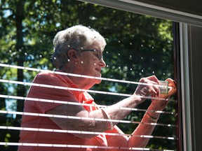 Taylor Bertelink/The Intelligencer
Jess Chambers, one of the 15 volunteers from the Quinte Field Naturalists put up "Feather Friendly" tape on all exterior windows at Quinte Conservation on Wednesday morning. Birds will see the small white squares placed on the exterior of the glass and will avoid flying into it thus preventing future bird strikes.