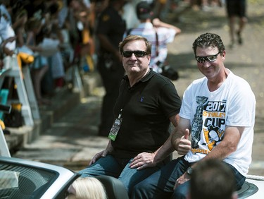 Pittsburgh Penguins co-owners Ron Burkle, left, and Mario Lemieux ride through the crowd during the team's Stanley Cup NHL hockey victory parade on Wednesday, June 14, 2017, in Pittsburgh.(Steph Chambers/Pittsburgh Post-Gazette via AP)