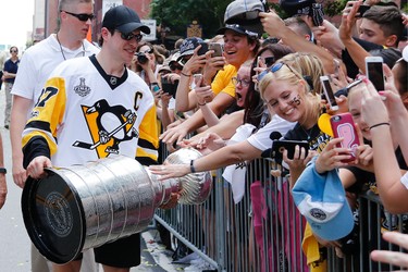 Pittsburgh Penguins' Sidney Crosby shares the Stanley Cup with fans lining route during the team's Stanley Cup NHL hockey victory parade on Wednesday, June 14, 2017, in Pittsburgh. (AP Photo/Gene J. Puskar)