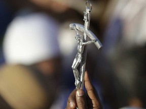 A person holding a crucifix, a symbol of catholic religion. ANDREW MEDICHINI / ASSOCIATED PRESS
