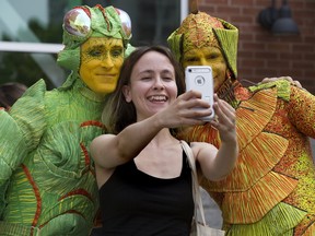 Amina Mackic takes a selfie with Cirque du Soleil performers Shawn Gregory as a cricket (left) and Tony Frebourg as a firefly following a lunchtime promotional appearance at the Covent Garden Market in London, Ont. on Tuesday June 13, 2017. (DEREK RUTTAN, The London Free Press)
