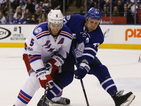 Toronto Maple Leafs forward Leo Komarov and New York Rangers defenceman Dan Girardi fight for the puck during an NHL game in Toronto on Feb. 24, 2017. (Jack Boland/Toronto Sun/Postmedia Network)