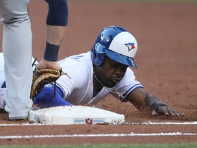 Blue Jays outfielder Dwight Smith Jr. dives back safely to first base on a pickoff attempt in the second inning on June 14, 2017. He was recalled after Ezequiel Carrera went on the DL. (TOM SZCZERBOWSKI/Getty Images)