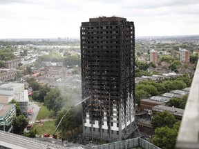 An automated hose sprays water onto Grenfell Tower, a residential tower block in west London that was caught in a huge blaze on June 14, 2017.
Firefighters searched for bodies today in a London tower block gutted by a blaze that has already left 12 dead, as questions grew over whether a recent refurbishment contributed to the fire. / AFP PHOTO / Tolga AKMENTOLGA AKMEN/AFP/Getty Images