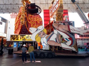 Workers remove the neon sign dubbed "Vegas Vickie" in downtown Las Vegas, Tuesday, June 13, 2017. The sign was taken down as part of the construction for a new resort-casino. (Steve Marcus /Las Vegas Sun via AP)