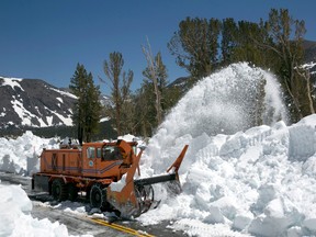 In this photo taken Tuesday, June 6, 2017, a Caltrans rotary blower clears snow from Highway 120 near near Yosemite National Park, Calif. (AP Photo/Rich Pedroncelli)