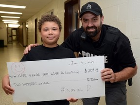 Submitted photo
Madoc Public School student Jamal Demorest presents Belleville police Const. Jeremy Ashley with a $209 donation. Demorest made the presentation toward Give Where You Live, a community fundraising effort hosted through the volunteer efforts of police officers from local Ontario Provincial Police detachments and the Belleville Police Service.
