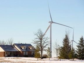 Giant wind turbines on the horizon dwarf a rural home near Kerwood, west of London, in this 2015 photograph. (London Free Press file photo)