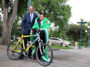 Premier Brian Pallister is joined at his bicycle by Southern Chiefs' Organization Grand Chief Jerry Daniels following a press conference at the Manitoba Legislature grounds in Winnipeg to kick off the premier's 160-kilometre bike tour between the original St. Peter's Reserve in East Selkirk and the current location of Peguis First Nation in the Interlake, on Thursday, June 15, 2017. Pallister presented a star blanket to Daniels during the event. Pallister is set to begin the trip Friday, June 16, 2017, with a goal of honouring the 200th anniversary of the Selkirk Treaty. JOYANNE PURSAGA/Winnipeg Sun/Postmedia Network